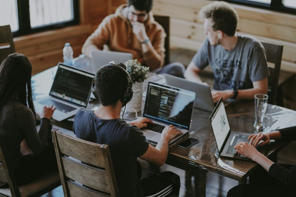 Equipo de redacción trabajando con portátiles en una mesa común